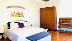A bedroom with a bed, a wooden wardrobe, a desk, and a painting on the wall. - Tuscany natural stone house with fireplace & panorama - quiet near Vinci, close to Florence (Mezzana)