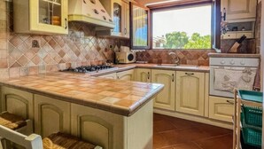 Une cuisine avec un îlot central, une cuisinière et une fenêtre.