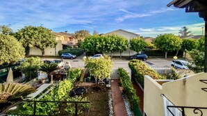 Un quartier résidentiel avec des maisons, des voitures garées et un jardin.
