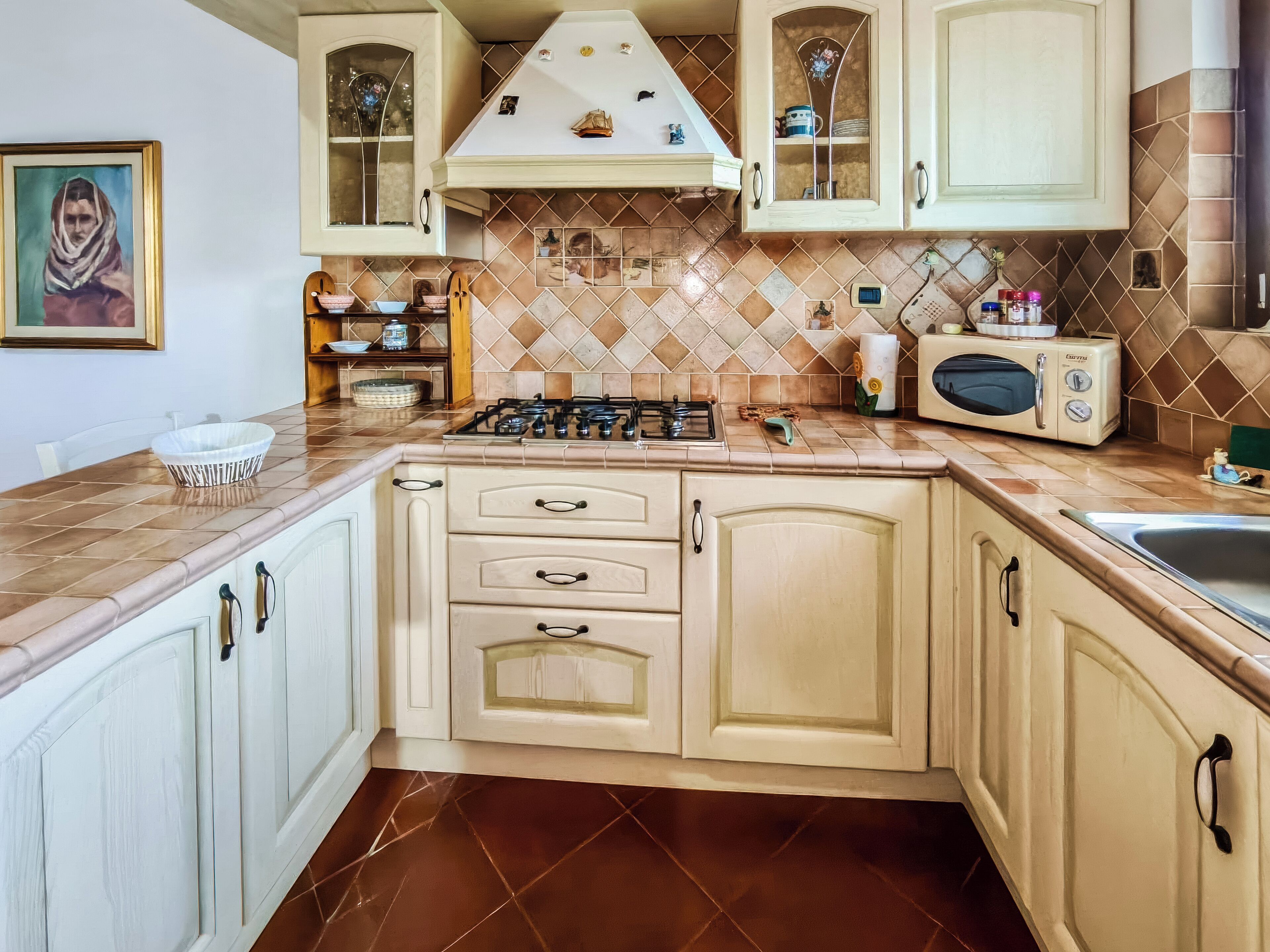 A kitchen with a gas stove, microwave, and cabinets.