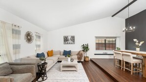 A spacious living room with a sofa, coffee table, and dining area.