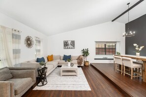 A spacious living room with a sofa, coffee table, and dining area. - 4BR Flower Mound Home w/ Backyard & BBQ Near Parks (Flower Mound)