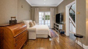 Ein Schlafzimmer mit Bett, Schminktisch, Fernseher und Treppe.