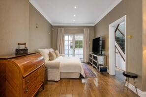 Ein Schlafzimmer mit Bett, Schminktisch, Fernseher und Treppe.