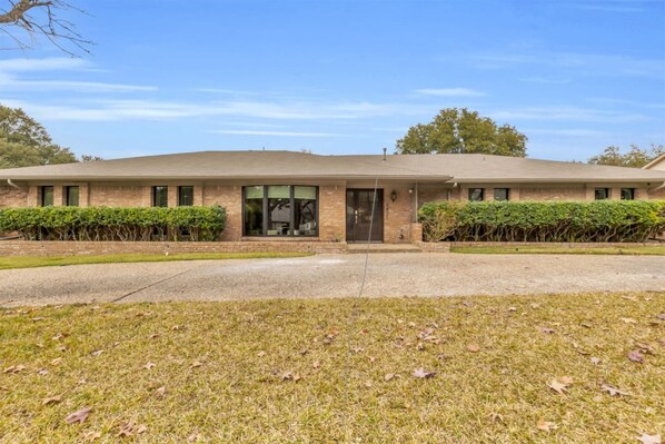 Front entry of a traditional Dallas home featuring a circular driveway, offering easy access, classic curb appeal, and convenient parking upon arrival.