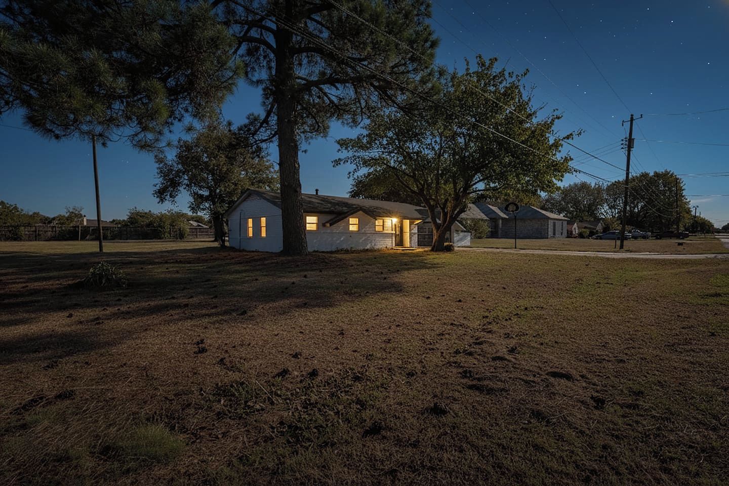 Dusk exterior of our Grand Prairie retreat. This 3-bed, 2-bath home sleeps 6 and features a spacious yard for kids or pets to play, plus plenty of parking for your group.