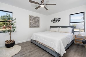 A calm and comfortable room featuring a King bed, TV with streaming channels, a ceiling fan, and crisp bed linens. Ideal for quiet nights in and a great night’s sleep.