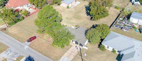 Expansive lot and charming neighborhood setting — see the full layout of this family-friendly Grand Prairie stay with open yard and tree-shaded driveway.