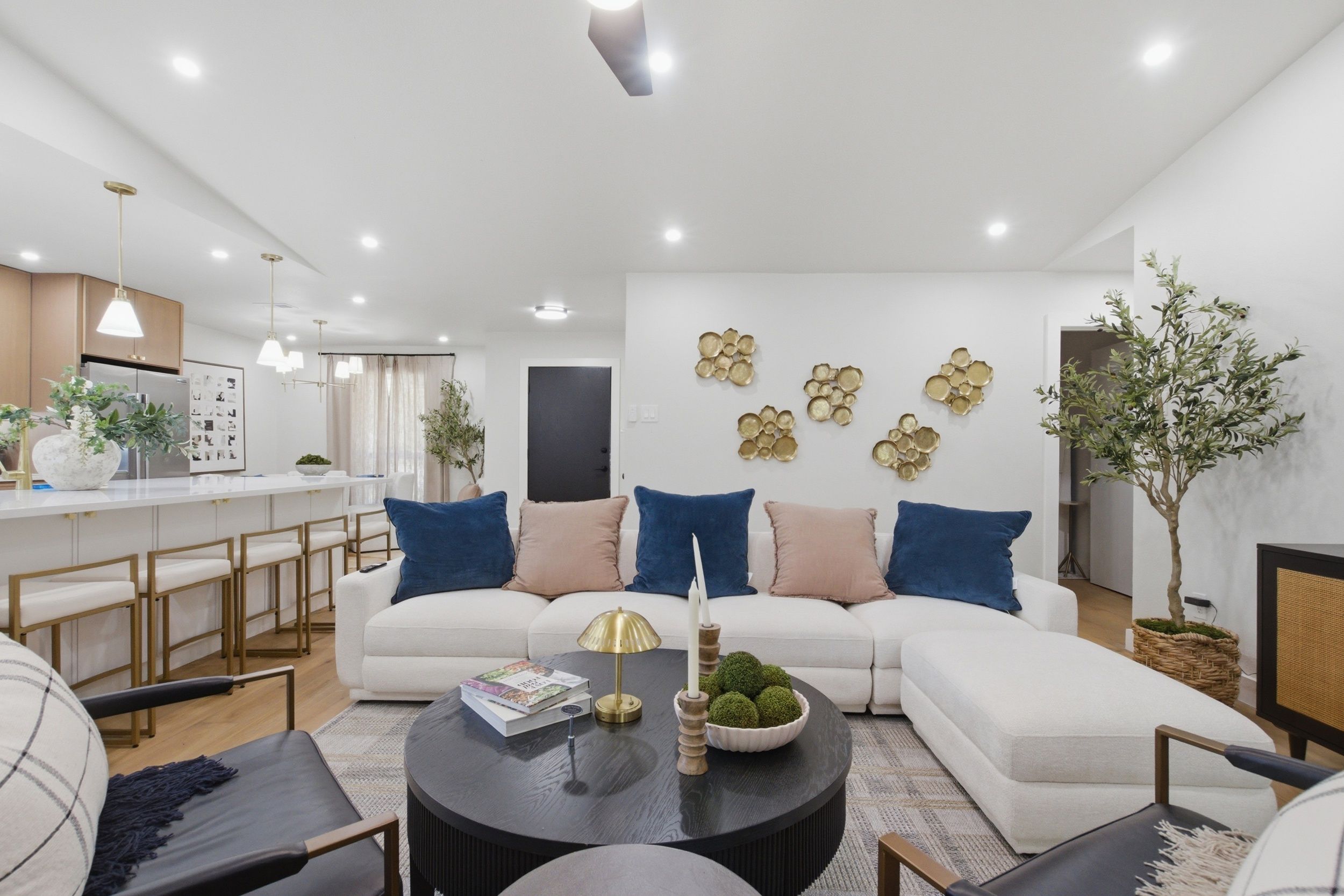 Un salon moderne avec un canapé d’angle, une table basse et un coin repas doté d’un bar.