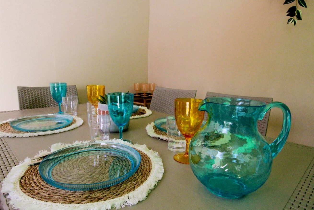 Una mesa de comedor con cristalería y una jarra.