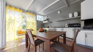 Una cocina con una mesa de comedor, sillas y una máquina de café.