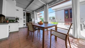 Una cocina moderna con comedor, ventanas amplias y vistas al exterior.