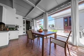 Una cocina moderna con comedor, ventanas amplias y vistas al exterior.