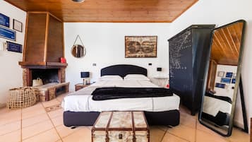 A bedroom with a bed, a fireplace, a mirror, and a map on the wall.