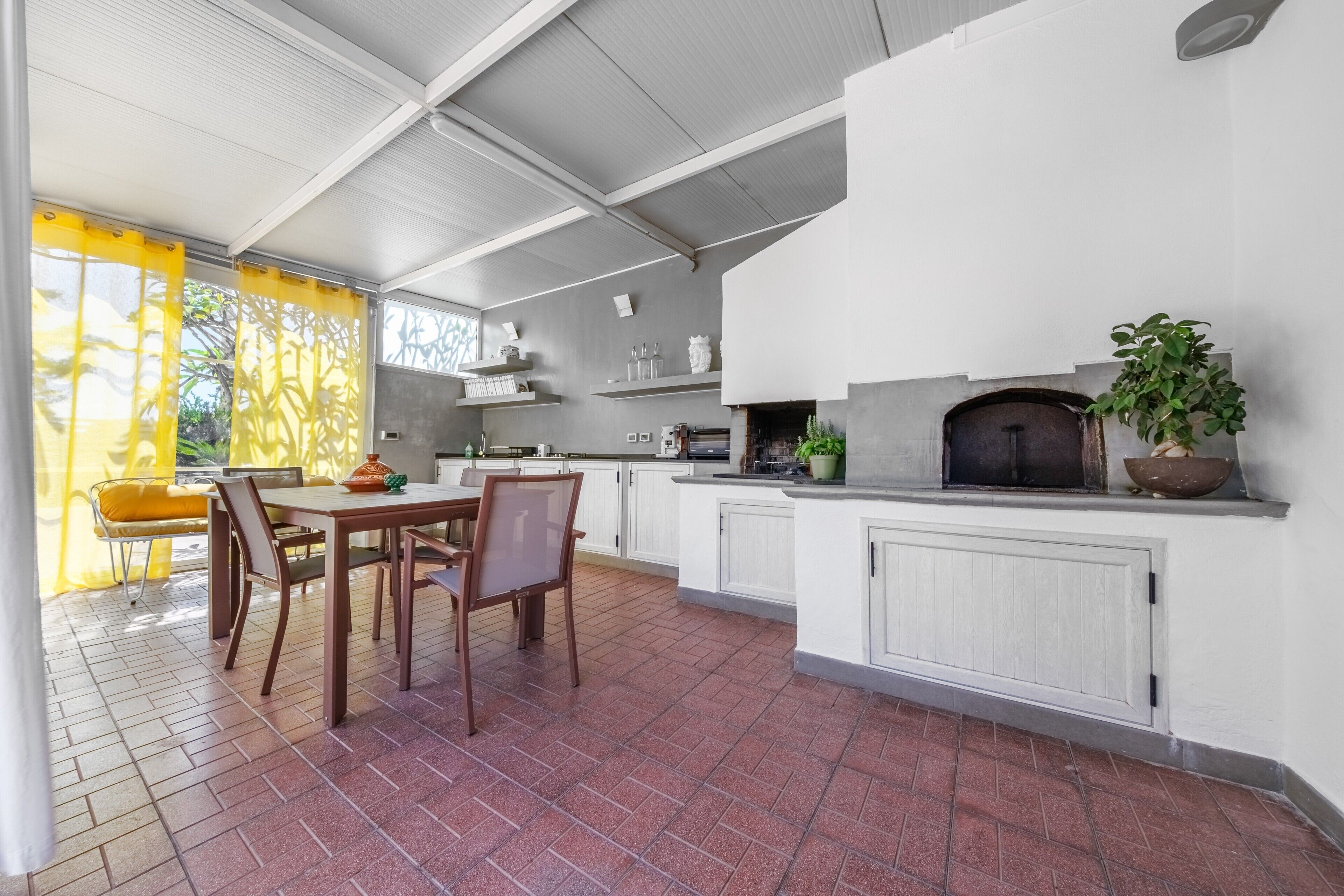 A modern kitchen with a central island, white cabinetry, and a built-in oven.