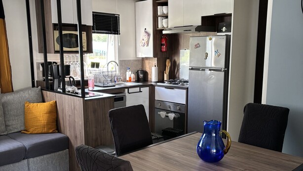 Une cuisine moderne avec un coin repas, un canapé et une table basse.