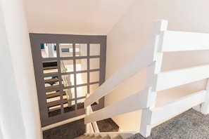 A staircase with a white handrail and a grey partition. - Modern 3BR Durham Stay for Work Trips (Brandon)