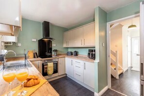A modern kitchen with a built-in oven, a sink, and a countertop with a toaster and coffee maker. - Modern 3BR Durham Stay for Work Trips (Brandon)