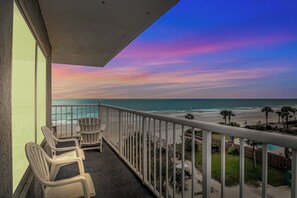 A balcony with chairs overlooking a beach and ocean. - Oceanfront Condo with Sunset Views (Myrtle Beach)