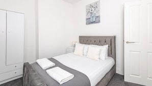 A bedroom with a bed, bedside tables, a wardrobe, and a painting on the wall. - *Discounts/Contractors/WIFI/Free Parking/Smart TV (Murton)