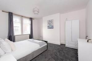 A bedroom with a bed, a wardrobe, a dresser, and a painting on the wall. - *Discounts/Contractors/WIFI/Free Parking/Smart TV (Murton)