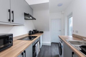 A compact kitchen with a microwave, coffee maker, and a washing machine. - *Discounts/Contractors/WIFI/Free Parking/Smart TV (Murton)