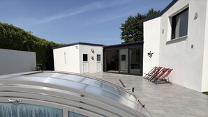 Un bâtiment moderne doté d’une piscine, d’un patio couvert et offrant une vue sur un ciel dégagé.