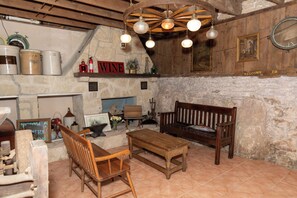 Um interior rústico com paredes de pedra, móveis de madeira, um aviso com a palavra 'vinho' e um sinal de boas-vindas.