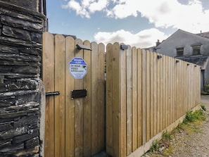 A wooden fence with a security alert sign indicating 24-hour video surveillance. - Park View Studio (Ambleside)