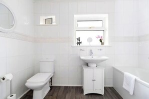 Un baño con inodoro, lavamanos y bañera.