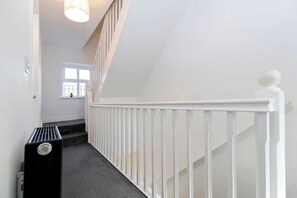 A staircase with a white railing and a radiator on the left. - Spacious 3BR | Gateshead | Perfect for Groups (Gateshead)