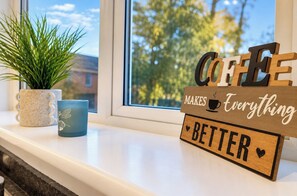 A window sill with a coffee sign, a potted plant, and a mug. - 2BR Home in Middlesbrough | Contractors Welcome (Normanby)