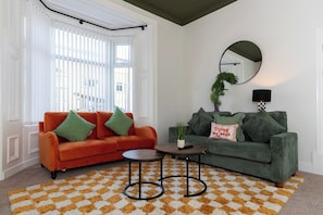 A living room with two sofas, a coffee table, a mirror, and a patterned rug. - Spacious 3BR • WiFi • Parking • Contractor Stay (Sunderland)