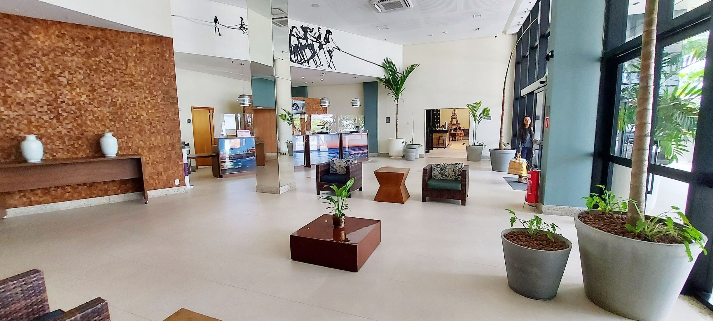 A spacious lobby with a reception desk, seating areas, and large windows allowing natural light.