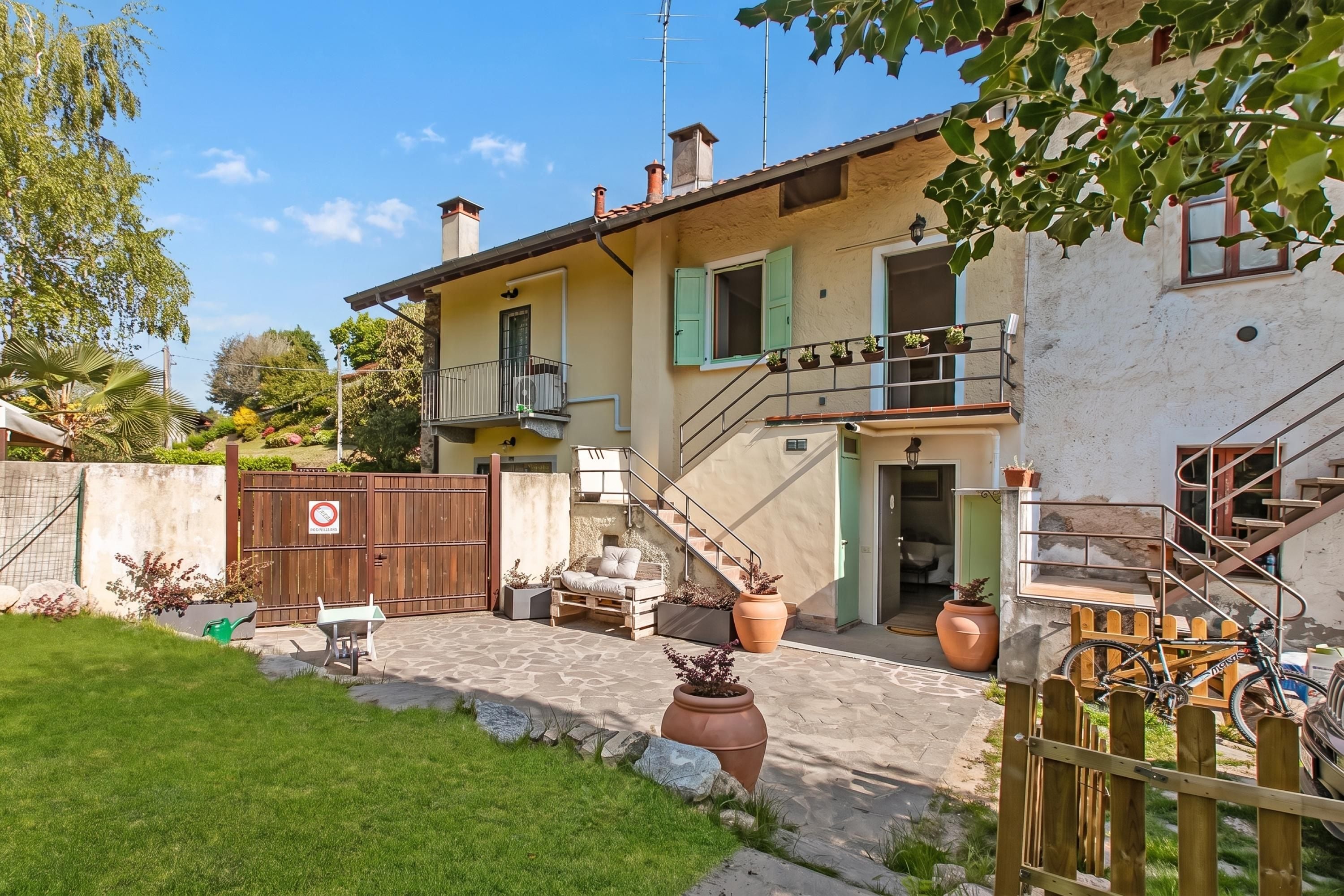 A two-story house with a balcony, a staircase, and a gate.
