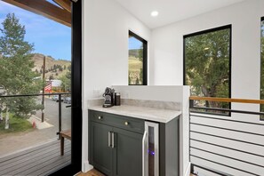 A modern kitchen with a built-in refrigerator, a coffee machine, and a window overlooking a street. - New Listing! Brand New Mountain Modern Home in the Heart of Downtown Creede (Creede)