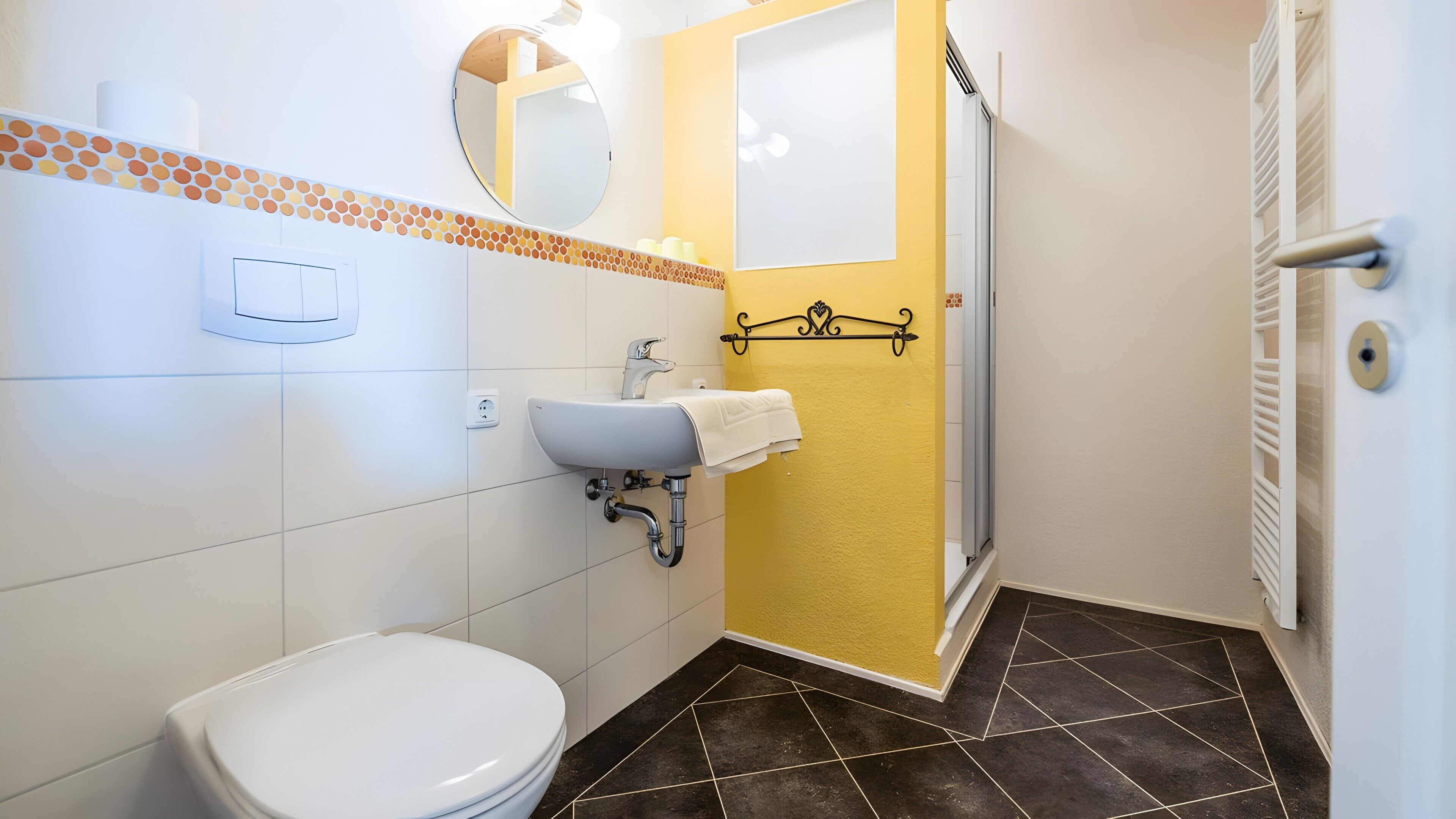 Un baño con inodoro, lavabo, espejo y ducha.