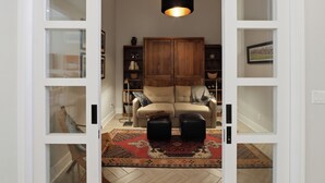 A room with a sofa, ottomans, a rug, a cabinet, and a hanging light fixture. - Luxury in Desert Ridge (Phoenix)
