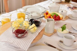 Desayuno con diversas opciones de comida, como frutas, yogur y jugo.