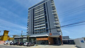 A multi-story hotel with a modern design, featuring a prominent entrance with a sign indicating it is for sale. - COSTE0112 - Premium Stella Maris (Salvador)