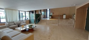 Ein modernes Wohnzimmer mit einer Couch, einem Couchtisch und einer Treppe, die in eine obere Ebene führt.