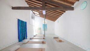 A yoga studio with wooden beams, mats, and cushions arranged for practice. - Wellness Garden Cottage with Yoga, Pilates and Natural Pond (Moncarapacho)