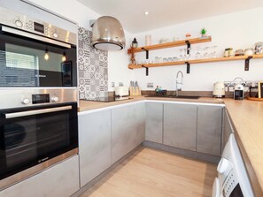 Eine moderne Küche mit Backofen von Bosch, einer eingebauten Spüle und einer Holzarbeitsplatte.