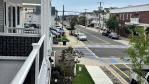 Una calle residencial con casas, aceras y coches aparcados.
