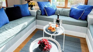 Un salon moderne avec un canapé, une table basse et une fenêtre donnant sur un paysage verdoyant.