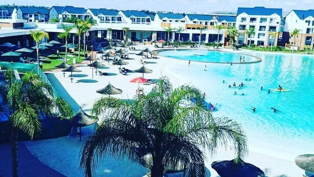 A resort with a large swimming pool, multiple lounge areas, and a variety of seating options. - The Blyde Modern Oasis Pretoria (Pretoria)