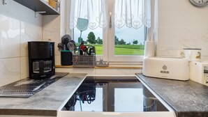 A modern kitchen with a built-in stove, coffee maker, and toaster.
