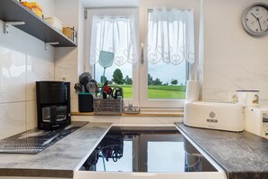 Une cuisine moderne équipée d’une cuisinière intégrée, d’une machine à café et d’un grille-pain.