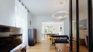 Een moderne woonkamer met een televisie, bank en eethoek.