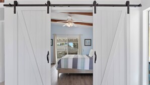 A bedroom with a bed, a ceiling fan, and a view through a sliding door. - 🌊 Palermo Paradise | 3BR Fort Myers Beach | Heated Pool + Porch Swing (Fort Myers Beach)